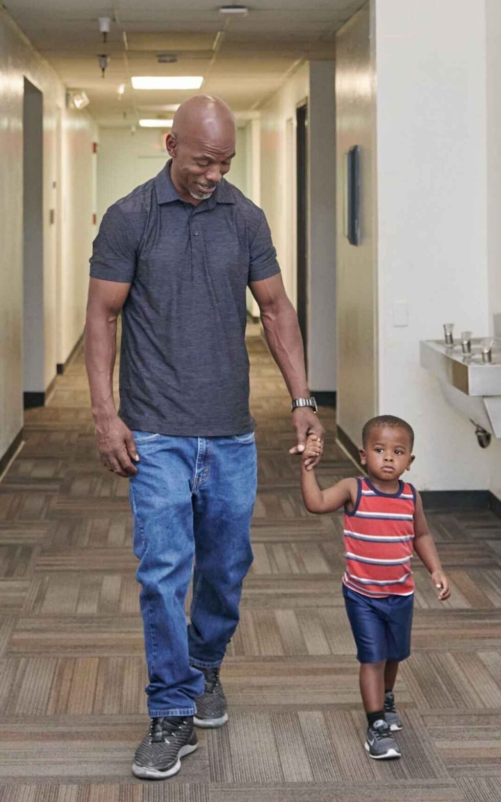 Mentor walking with child in school hallway